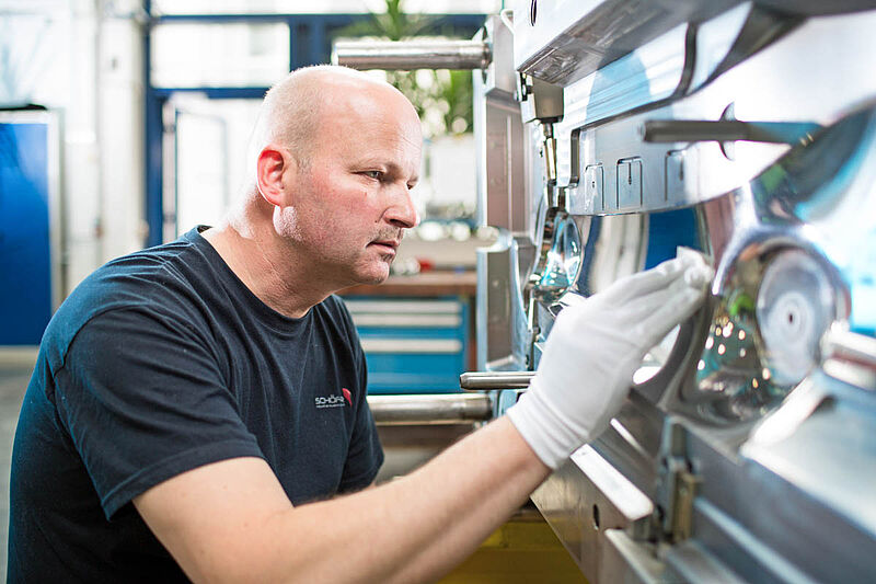 Mitarbeiter bei der Oberflächenbearbeitung einer Spritzgussform